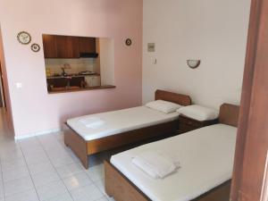 ein Zimmer mit zwei Betten und einer Küche in der Unterkunft Platanias Hillside in Platanias