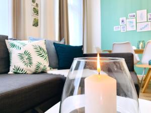 uma vela sentada numa mesa numa sala de estar em Zentrumsnahe Ferienwohnung mit ruhigem Balkon - "Arthur" em Leipzig