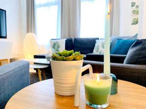 een kaars en een vaas op een tafel in een woonkamer bij Zentrumsnahe Ferienwohnung mit ruhigem Balkon - "Arthur" in Leipzig