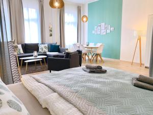 uma sala de estar com uma cama grande no meio de um quarto em Zentrumsnahe Ferienwohnung mit ruhigem Balkon - "Arthur" em Leipzig
