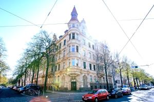 ein großes Gebäude, vor dem Autos parken in der Unterkunft Gemütliche Ferienwohnung neben der Arena Leipzig "Waldi" in Leipzig