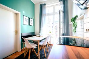 ein Esszimmer mit Tisch und Stühlen und einem Fenster in der Unterkunft Gemütliche Ferienwohnung neben der Arena Leipzig "Waldi" in Leipzig