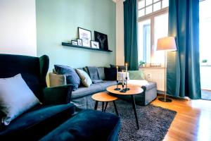 ein Wohnzimmer mit Sofa und Tisch in der Unterkunft Gemütliche Ferienwohnung neben der Arena Leipzig "Waldi" in Leipzig