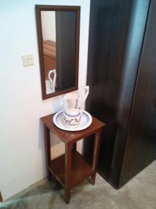 una pequeña mesa con un espejo y un jarrón en ella en Cortijo Jayon, en Fernán Pérez