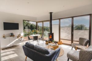 a living room with a couch and chairs and a fireplace at "Constable" Eco Lodge with Private Hot Tub in East Bergholt