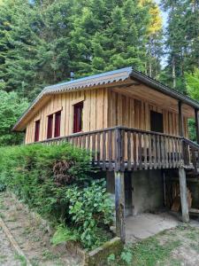 eine kleine Holzhütte mit Balkon im Wald in der Unterkunft Chalet de la forêt 1 à 6 pers in Saint-Sauveur