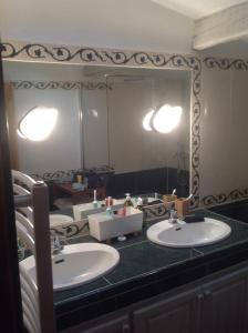 a bathroom with two sinks and a large mirror at Chambre d hôte Entre Cigale et Pagnol in Peypin