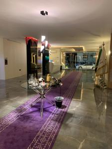 Cette chambre comprend une table et un tapis violet. dans l'établissement Golden New Al Safa, à Djeddah