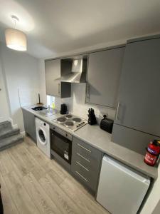 a kitchen with a stove and a washing machine at Storey Apartment - 2 Bedroom upstairs flat in Newbiggin-by-the-Sea