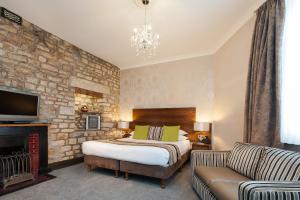a bedroom with a bed and a stone wall at The Sun Hotel & Bar in Lancaster