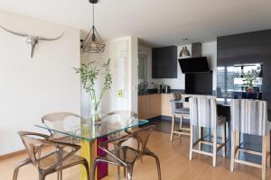 ein Esszimmer und eine Küche mit einem Glastisch und Stühlen in der Unterkunft Spacious cocoon with terrace just outside Paris in Pantin