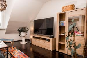 a living room with a television in a wooden entertainment center at Stadt-Ferienwohnung in Bad Lauterberg