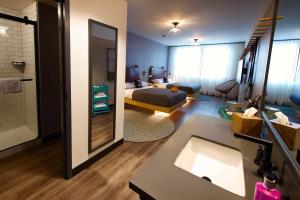 MOXY New Orleans Downtown/French Quarter Area في نيو أورلينز: حمام مع سرير ومغسلة في الغرفة