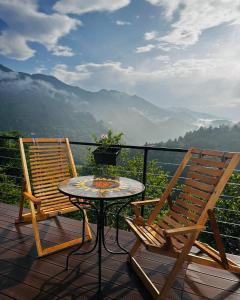 a table and two chairs on a balcony with a view at One day in the village/ერთი დღე სოფელში in Batumi