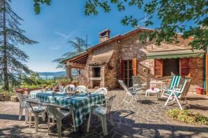 a table and chairs in front of a stone house at Villa Due Laghi in San Feliciano