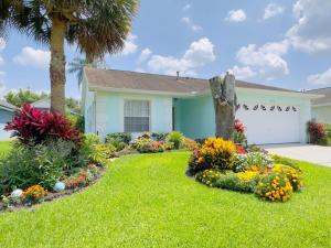 a house with a garden with flowers in the yard at 1566 Oak Hill Trail Villa #105715 Villa in Orlando