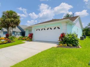 una casa con un garage bianco con una palma di 1566 Oak Hill Trail Villa #105715 Villa a Orlando