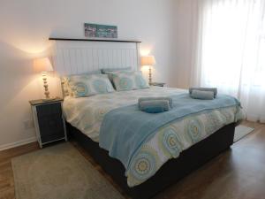 a bedroom with a large bed with a blue comforter at Rivertides Self Catering Guest House in Velddrif