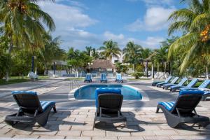 a resort pool with chairs and a swimming pool at Hotel Calypso Cancun in Cancún