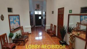 un pasillo con sillas, una mesa y una puerta en Hotel Conquistador Veracruz en Veracruz