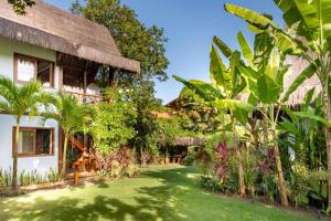 a house with a grass yard in front of it at Aldeia dos Corais - Taipu de Fora in Barra Grande