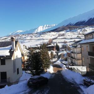 una ciudad cubierta de nieve con edificios y una montaña cubierta de nieve en Nicola's house en Campo di Giove