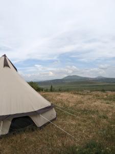 a tent sitting in the middle of a field at Campy Mountain Campsite in Tkhit