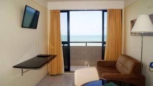 a living room with a couch and a window with a view at CJC Short Stay Natal in Natal