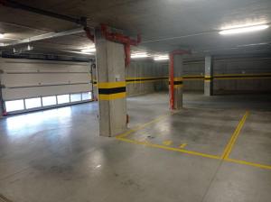 een lege parkeergarage met gele en zwarte palen bij Nowoczesny apartament 07 in Sianozety