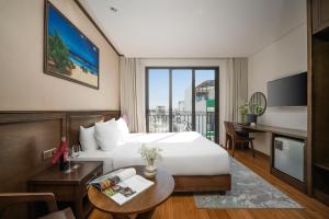 ダナンにあるGolden Lotus Hotel Da Nang - Rooftop Bar Sea Viewのベッド、デスク、バルコニーが備わるホテルルームです。 +44枚の写真