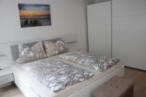 a white bedroom with a bed and a picture on the wall at Ferienwohnung Jasmin in Traben-Trarbach