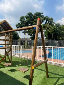 un parque infantil con columpio junto a una piscina en LD House luxury, en Cali
