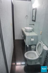 a bathroom with a toilet and a sink at Dodo Plaza Machado in Mazatlán