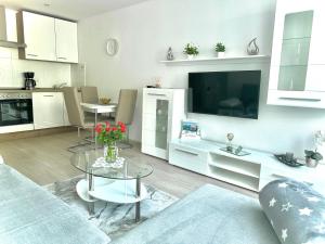 a living room with a glass table and a kitchen at Ferienwohnung Jasmin in Traben-Trarbach