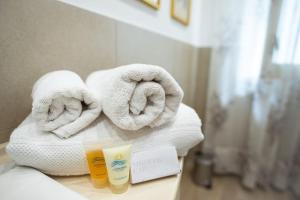 een stapel handdoeken op een aanrecht in een badkamer bij Gardenia Home in Palermo
