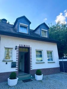 a white house with two plants in front of it at Ferienwohnung Jasmin in Traben-Trarbach