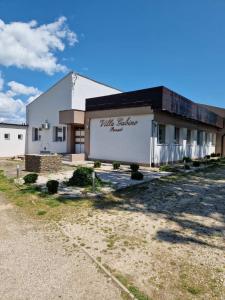 a white building with a sign on the side of it at Villa Gabino in Balatonberény