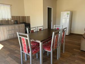 a kitchen with a table with chairs and a refrigerator at Cabañas PH in Trevelin