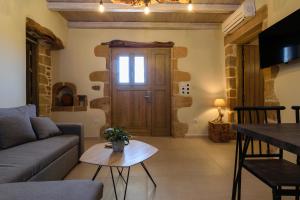 a living room with a couch and a table at Effrosini Traditional Home in Nopíyia
