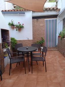 eine Terrasse mit einem Tisch, Stühlen und einem Kamin in der Unterkunft El patio de Marcos in La Recueja