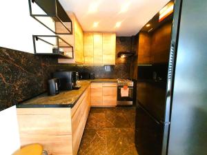 uma cozinha com armários de madeira e um frigorífico preto em HappyStay Gold em Gliwice