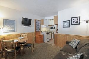 sala de estar con sofá, mesa y cocina en Affordable Breck Getaway with Recent Updates, Spacious Lobby, Outdoor Hot Tubs PM2B, en Breckenridge