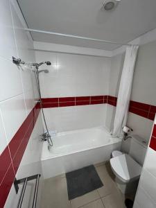 a bathroom with a white tub and a toilet at Alcalá Center Playa in Alcalá