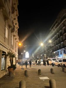 grupa ludzi idących nocą ulicą w obiekcie Nase e cane home Napoli w mieście Napoli