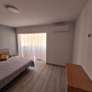 a bedroom with a bed and a table and a window at Apartament Lux in Vinarós