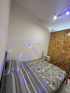 Un dormitorio con una cama con luces moradas. en Casa panoramica zoosafari en Selva di Fasano