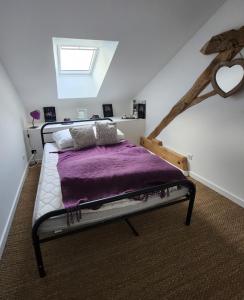 Les naturelles في Saint-Aubin-de-Locquenay: غرفة نوم بسرير وبطانية ارجوانية