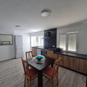 a kitchen with a table and chairs and a refrigerator at Apartament Lux in Vinarós