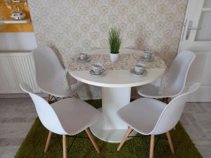 un tavolo bianco con quattro sedie e una pianta sopra di Apartman Marija a Paraćin