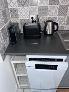 eine Küche mit einer Arbeitsplatte mit einem Toaster und einem Gerät in der Unterkunft La petite lumière Dieppoise in Dieppe